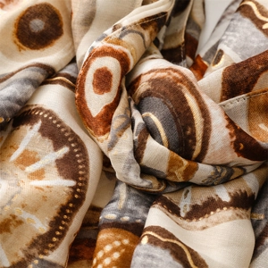 Macro detail of abstract geometric print scarf with delicate gold foil accents