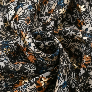 Detailed close-up of floral print fabric with gold foil accents and cotton linen texture