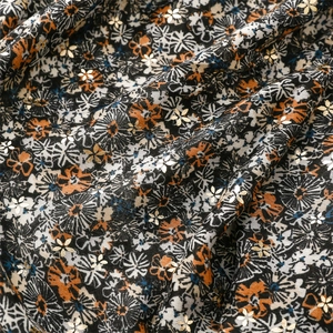 Detail of floral linen scarf fabric with gold foil accents and small daisy patterns