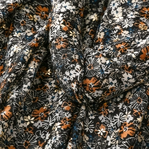 Detail of floral linen-feel scarf with golden foil chrysanthemums and soft texture