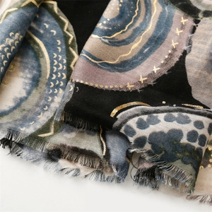 Detail of artistic cotton scarf with gold foil geometric stars and soft fringe edges