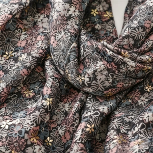 Close-up of linen-feel scarf featuring floral patterns and gold foil flower stamping details