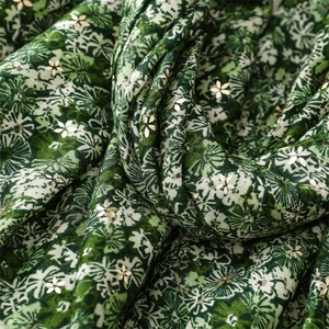 Detail of green floral scarf with golden star foil printing and soft fabric texture