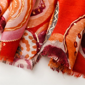 Close-up of geometric gold foil print on a warm-toned cotton linen scarf with eyelash fringe