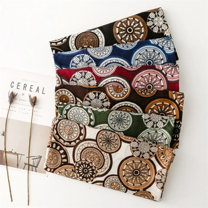 Detail view of cotton linen scarves with vintage geometric wheel patterns in multiple colors