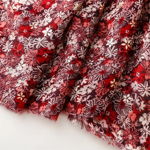Detail of red floral cotton linen scarf with elegant gold stamping and frayed edges