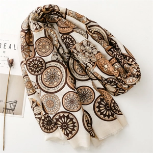 Macro detail of geometric foil floral patterns and soft tassels on a linen-feel scarf