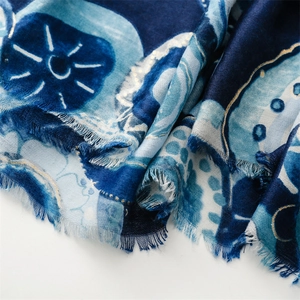 Macro shot of abstract pattern scarf with gold embroidery and frayed edge details