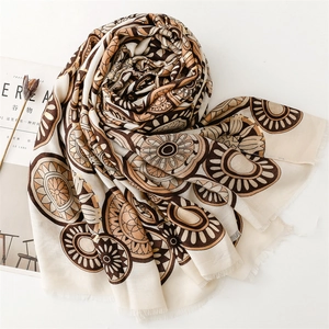 Close-up of mandala patterns and fringe texture on a beige cotton linen scarf