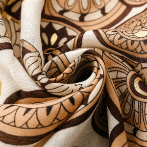 Macro detail of cotton-linen scarf featuring gold foil mandala patterns and rich textures