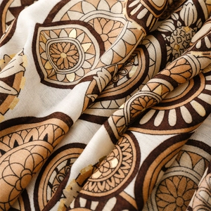 Detailed close-up of mandala patterns and gold foil prints on a warm winter scarf