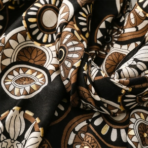 Close-up of geometric gold foil mandala pattern on black and white cotton linen scarf
