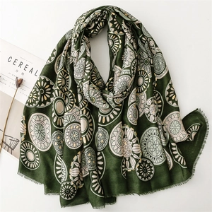 Detail of dark green cotton linen scarf with gold mandala patterns and tassel edges
