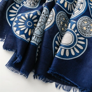 Detail of navy blue cotton linen scarf featuring gold foil geometric wheel patterns and fringe
