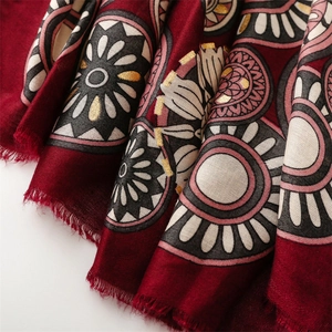 Close-up of deep red cotton linen scarf with gold geometric pattern and fringe edges
