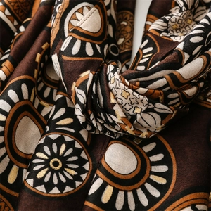 Detailed close-up of geometric gold foil wheel patterns on a soft cotton linen shawl