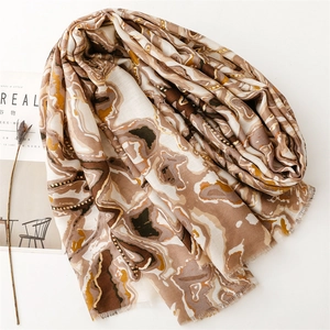 Détail d'une écharpe à motif marbré avec bords à franges et tons de terre chauds