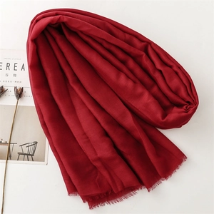 Solid deep red cotton linen scarf with frayed edges shown in a minimalist flat lay