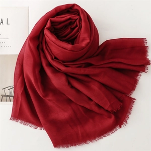 Detail of dark red scarf fabric showing lightweight linen texture and fringed edges