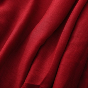Detailed macro view showing the texture and fringe of the soft red cotton linen shawl