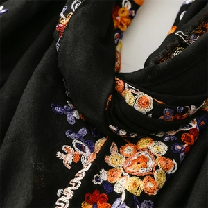 Detail of colorful floral embroidery on high-quality black cotton linen texture scarf