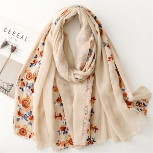 Detail of light beige scarf featuring vintage floral embroidery and soft cotton feel
