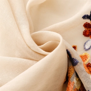 Macro detail of breathable linen-feel fabric with ethnic floral embroidery patterns