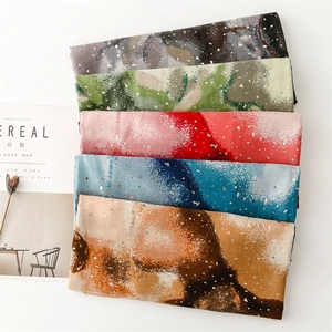 Detailed view of colorful abstract print scarves with elegant gold foil speckled texture