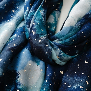 Macro detail of navy blue scarf with golden foil stars and abstract渲染 texture