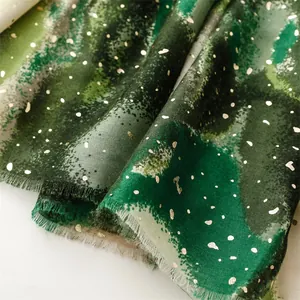 Close-up of emerald green gradient scarf with gold foil accents and frayed edges