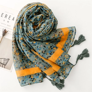 Detail of light cotton-linen floral scarf with yellow stripe border and soft fringe