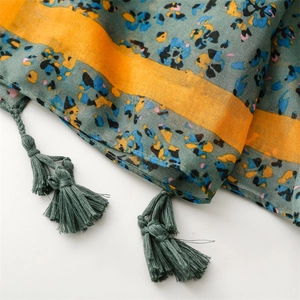 Macro detail of cotton linen scarf with abstract floral prints and fringe tassels