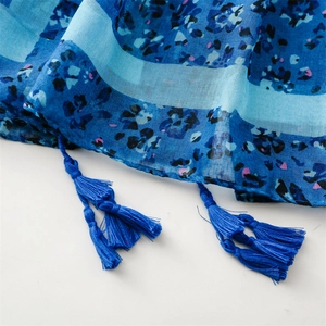 Detail of blue floral cotton linen scarf featuring tassel edges and woven texture