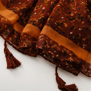 Close-up of brown floral scarf with cotton-linen feel fabric and handmade fringe tassels