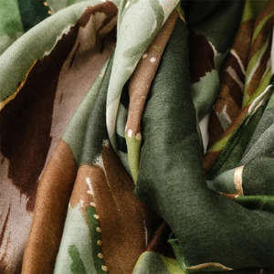 Dettaglio macro di sciarpa in lino e cotone con motivo astratto e puntini d'oro