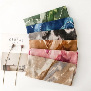 Close-up of lightweight scarves with ethnic gold wave patterns in six assorted colors