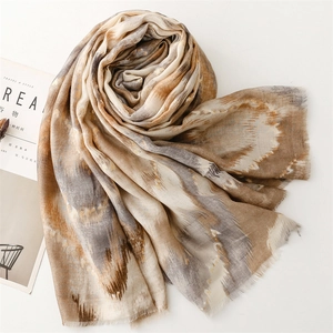 Detailed macro view of Earth-tone abstract print scarf with soft fringe edges and cotton-linen texture