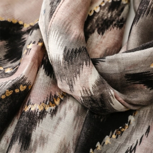 Detail of soft linen scarf with gold foil heart motifs and colorful wave patterns