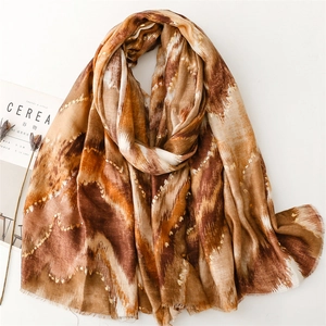 Detailed texture of wave-patterned scarf with gold glitter and fringe edges