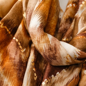 Close-up of soft cotton linen scarf with gold foil dots and wavy mountain texture