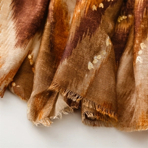 Detailed view of the gold foil texture and frayed edges on the mountain pattern scarf