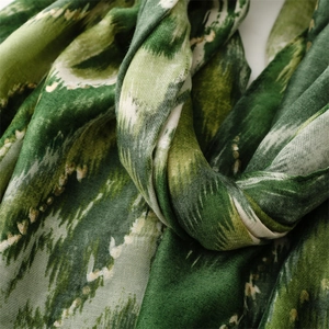 Detail of soft linen-touch scarf with green gradient wave pattern and fine woven texture