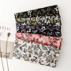 Detail of floral linen-feel scarves with gold foil print in five various colors
