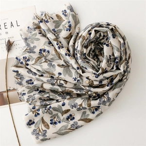 Detailed texture of cotton linen scarf featuring floral prints and frayed tassel edges