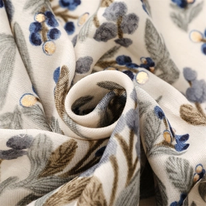 Detailed macro shot of vintage floral print scarf with gold accents and twill texture