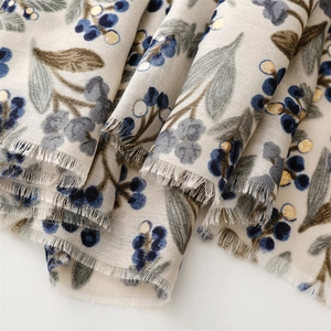 Detail of floral linen scarf with gold foil accents and soft fringe edges in elegant style