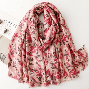 Pink cotton linen scarf with gold floral patterns and fringe edges on white background