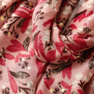 Macro shot of pink cotton-linen scarf with floral patterns and gold foil polka dots