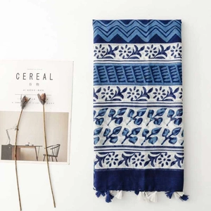 Detail of blue and white floral scarf with tassels and decorative cereal magazine props