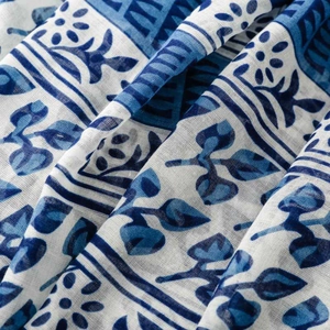 Close-up of lightweight blue and white porcelain pattern fabric with floral print details